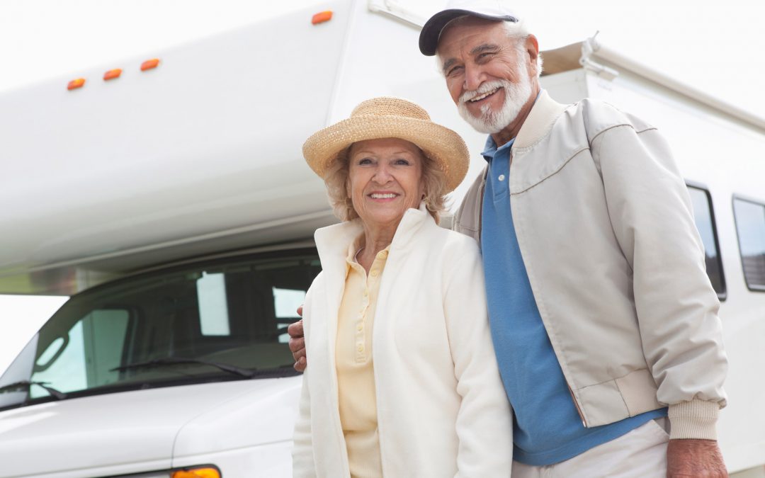 A couple poses outside their RV. This blog covers what is the best RV for a retired couple